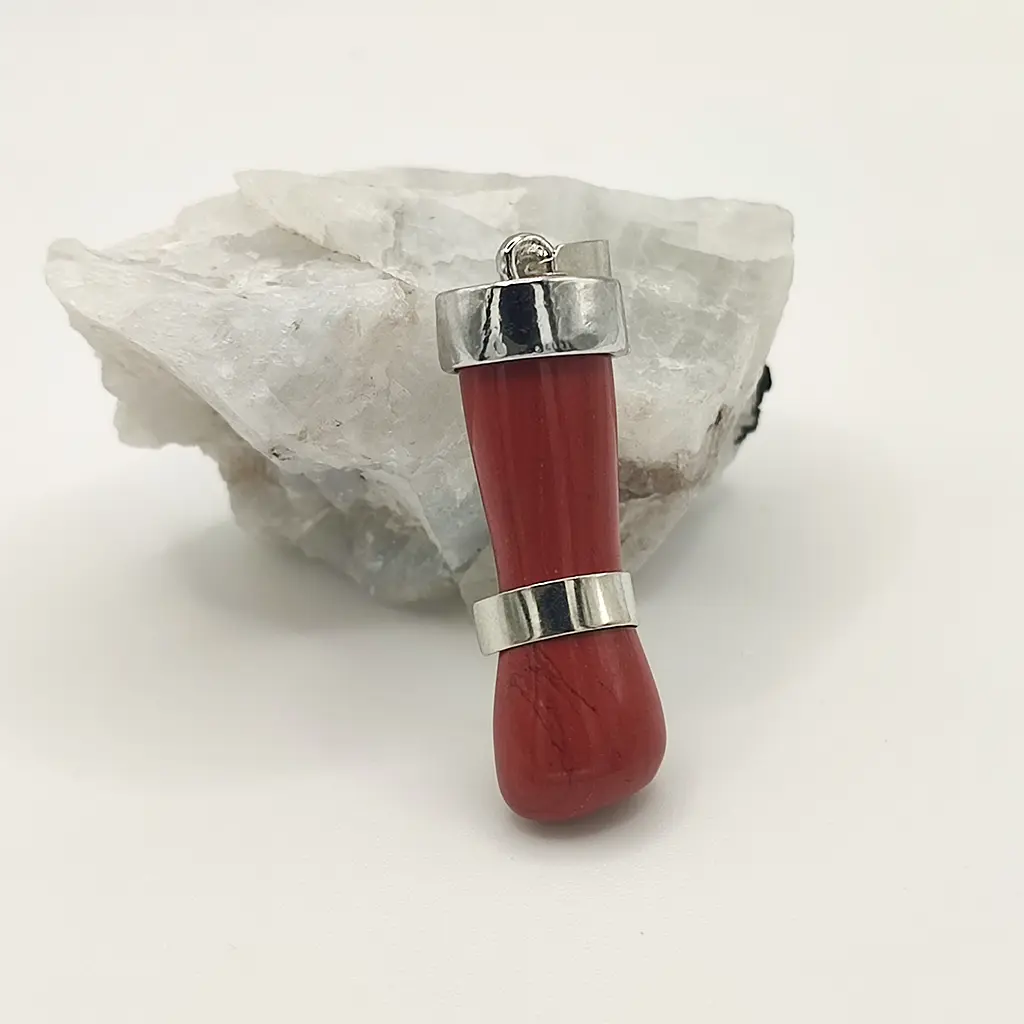 Colgante de puño Figa en jaspe rojo con detalles metálicos sobre fondo blanco