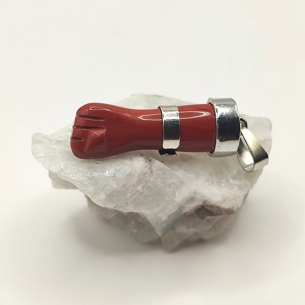 Colgante de puño Figa en jaspe rojo con detalles metálicos sobre fondo blanco