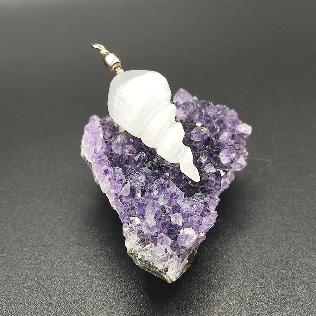 Colgante tallado en espiral con piedra de selenita blanca sobre drusa de amatista