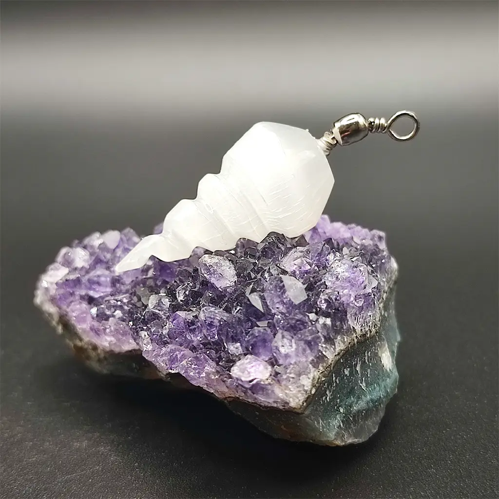 Colgante tallado en espiral con piedra de selenita blanca sobre drusa de amatista