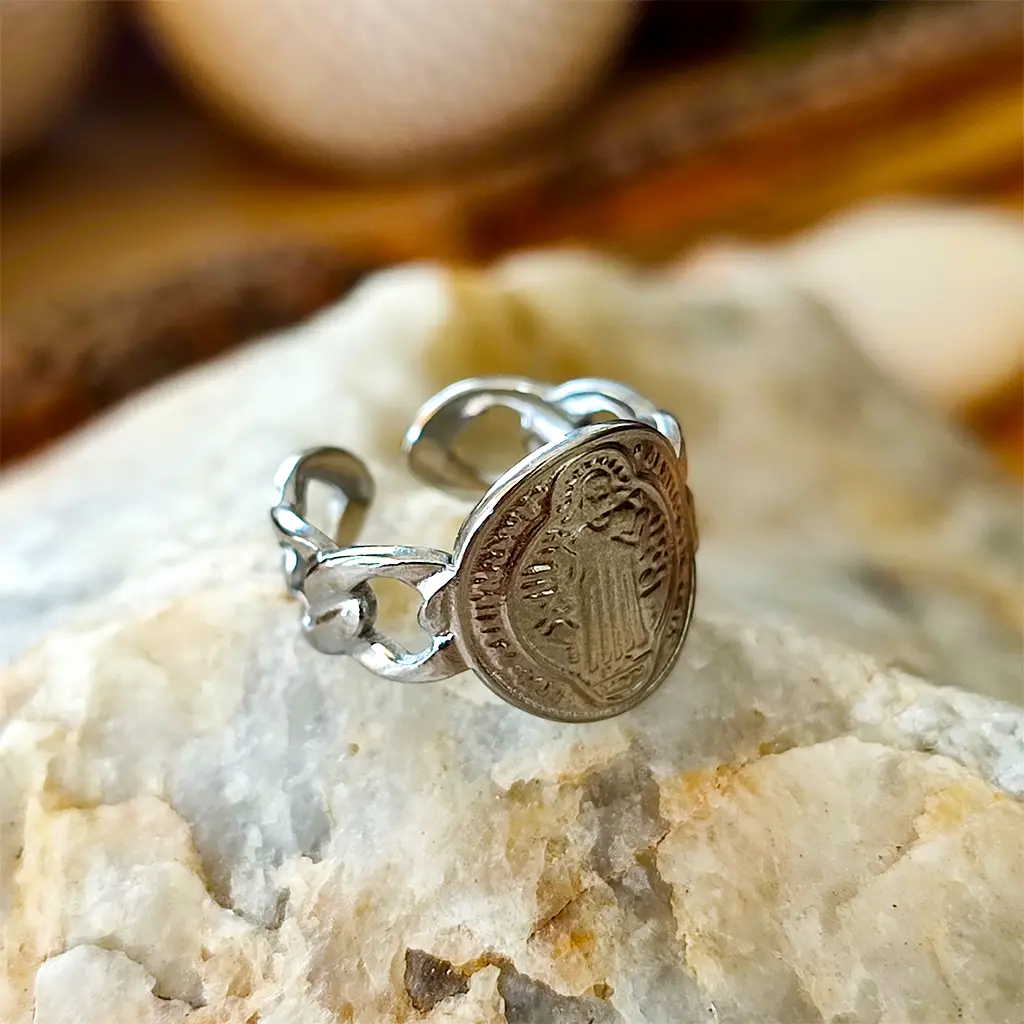 anillo plateado con medalla de San Benito y diseño de eslabones