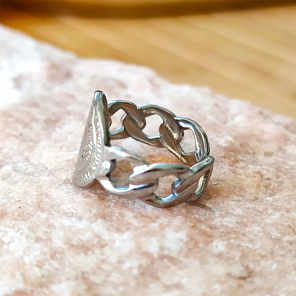 anillo plateado con medalla de San Benito y diseño de eslabones