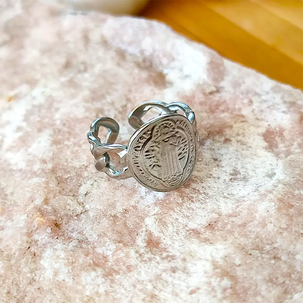 anillo plateado con medalla de San Benito y diseño de eslabones