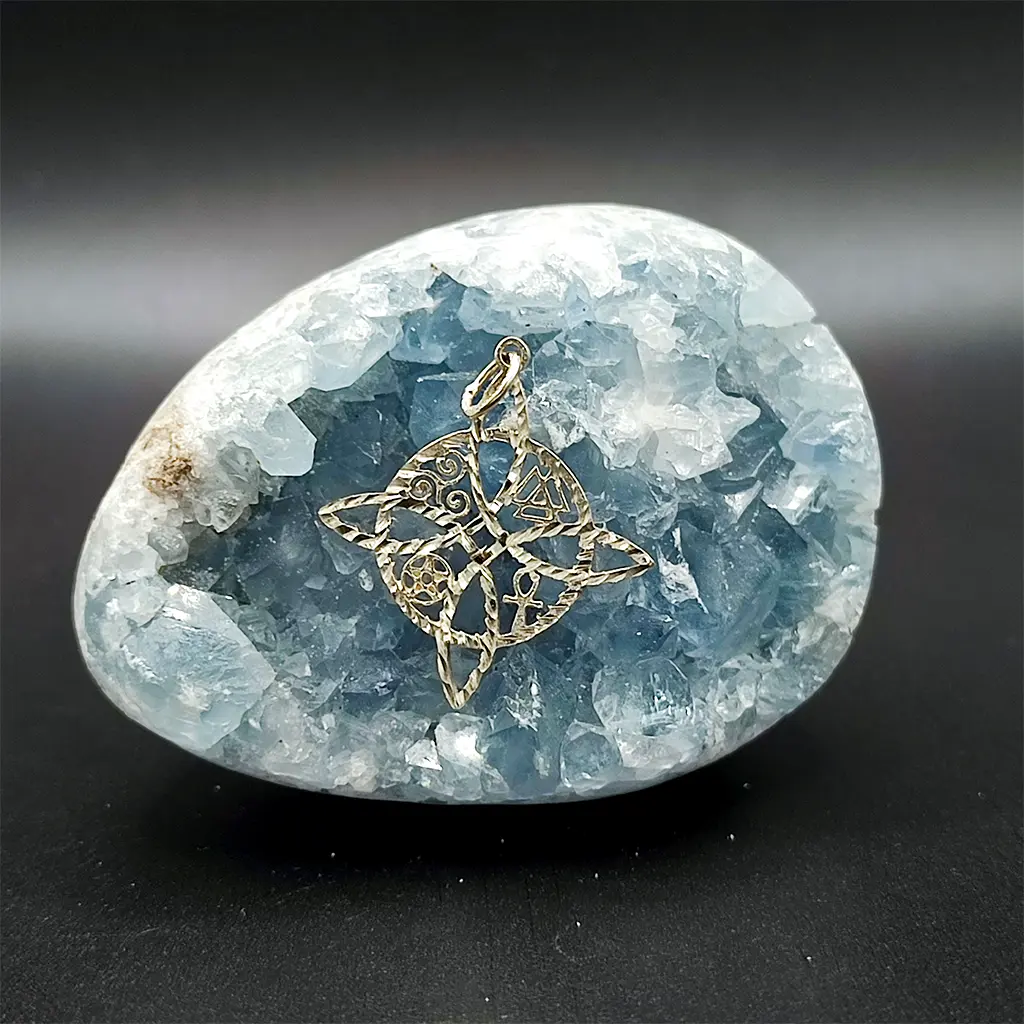 colgante de plata con símbolos mágicos y esotéricos sobre piedra celeste