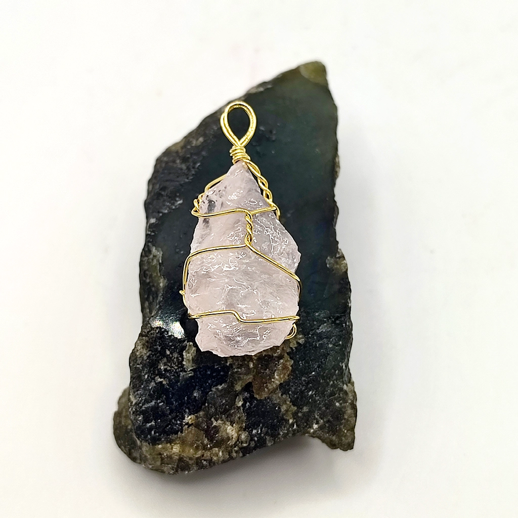 Colgante de cuarzo rosa en bruto envuelto en alambre dorado