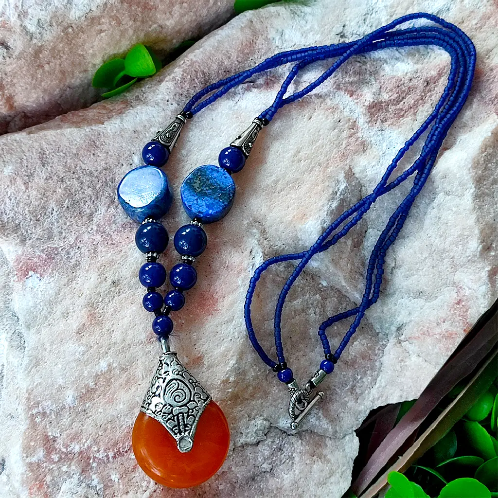 Collar artesanal indio azul con colgante naranja y detalles étnicos
