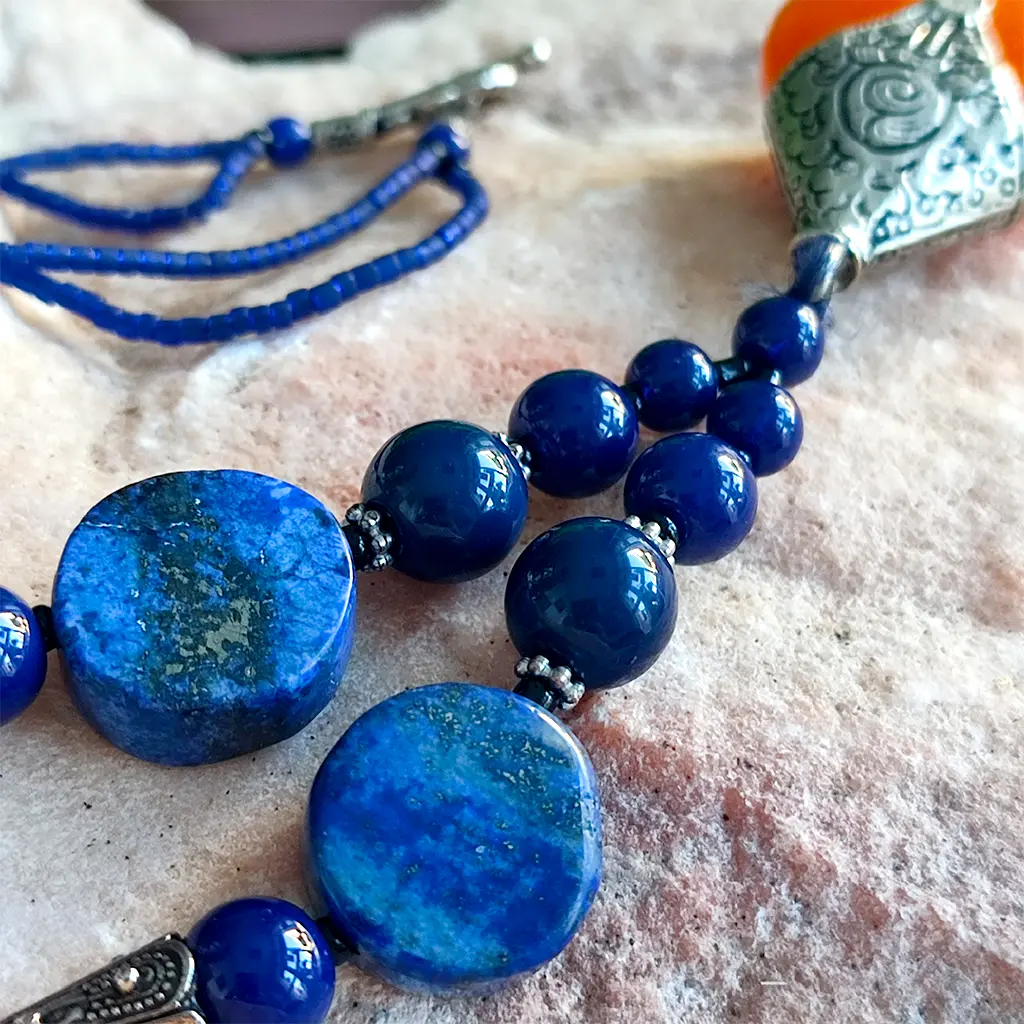 Collar artesanal indio azul con colgante naranja y detalles étnicos