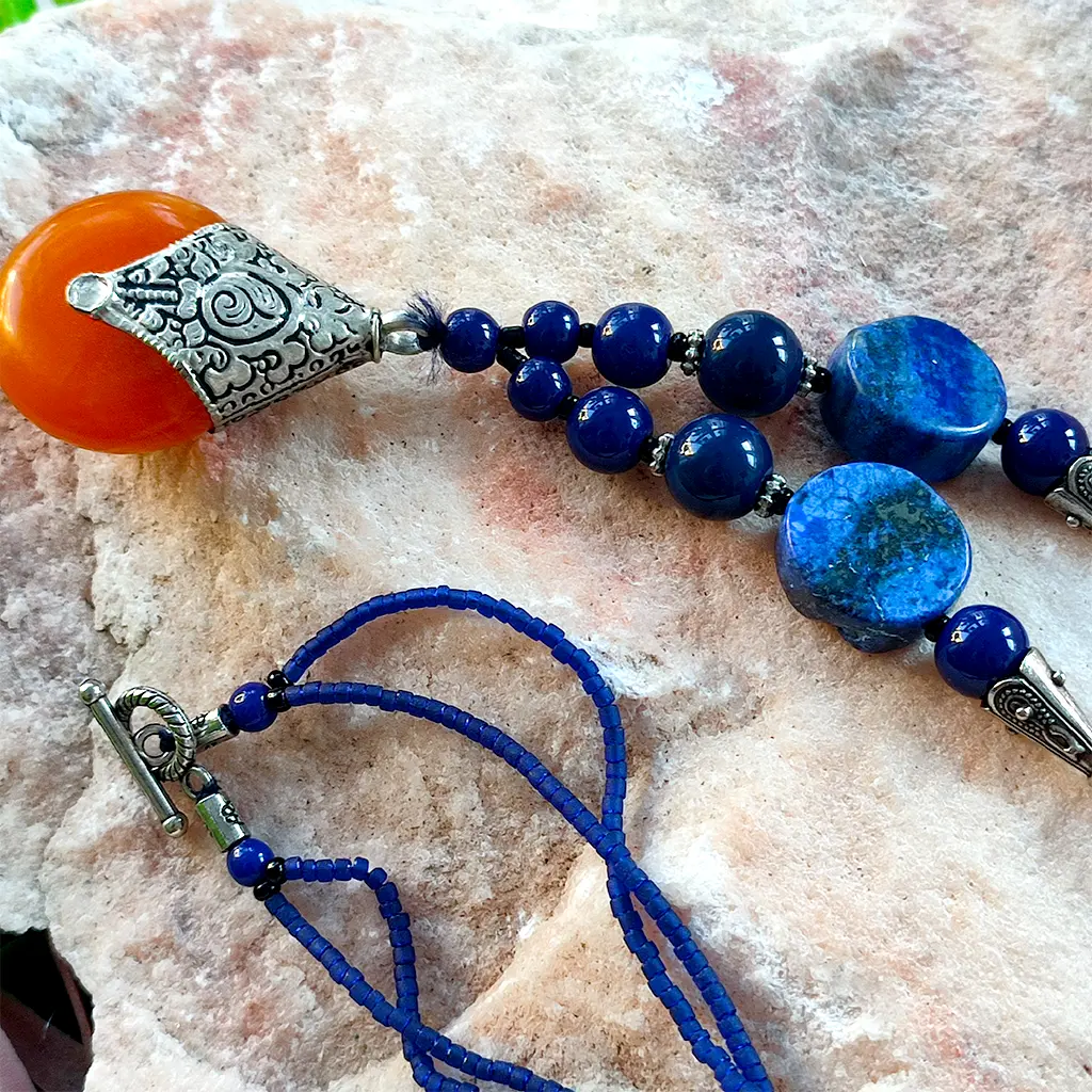 Collar artesanal indio azul con colgante naranja y detalles étnicos