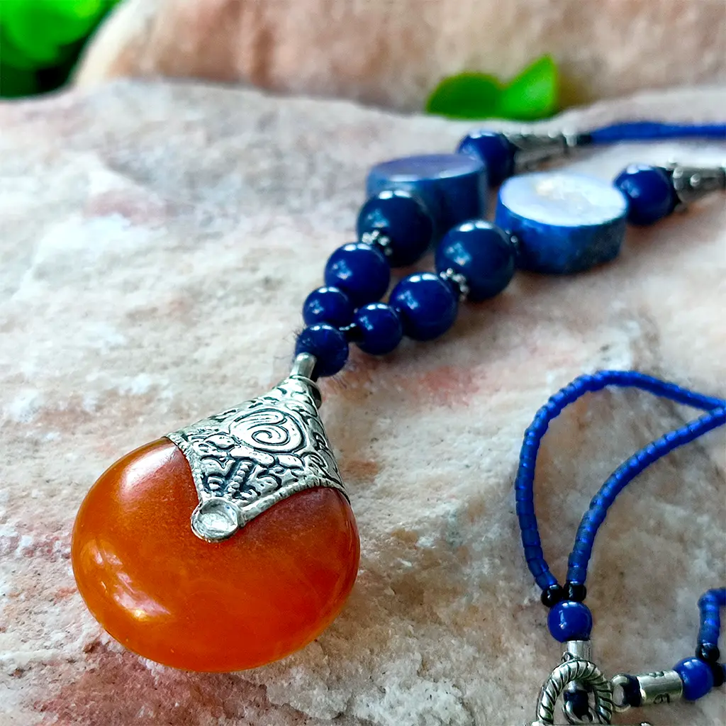 Collar artesanal indio azul con colgante naranja y detalles étnicos