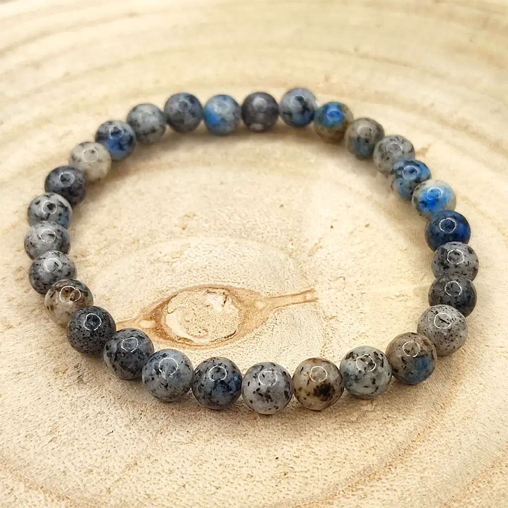 Pulsera de Piedra K2 natural de 6 mm con inclusiones azules sobre matriz gris.