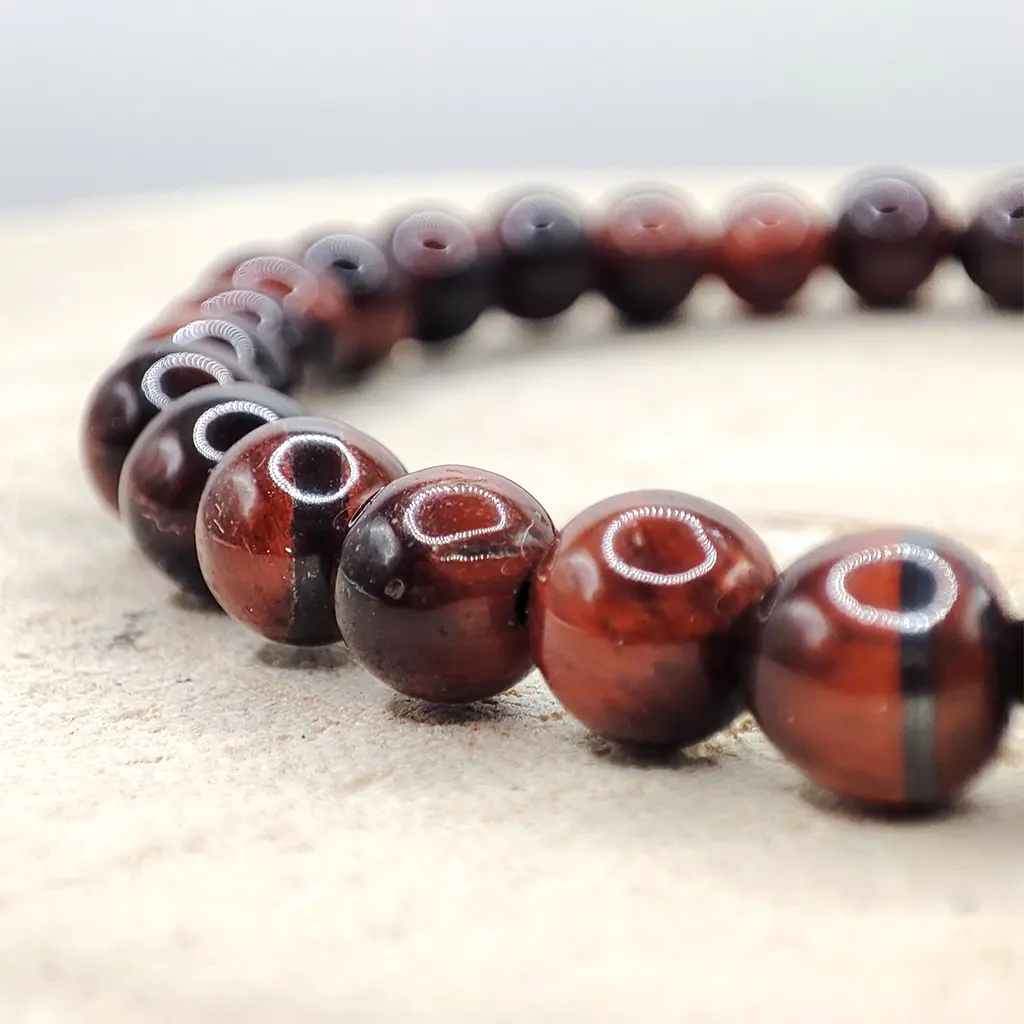 Pulsera de Ojo de Buey natural de 6 mm en tonos rojizos y marrones.