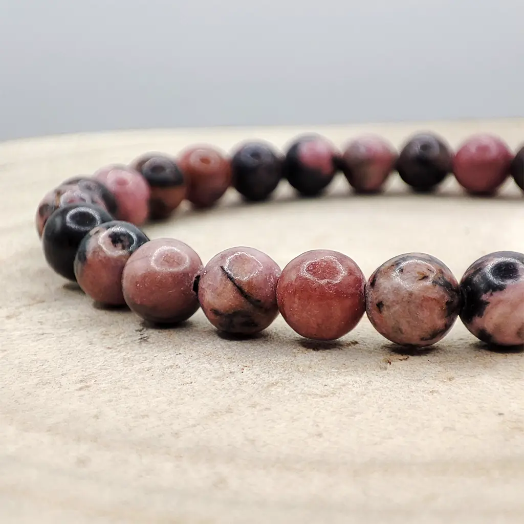 Pulsera de Rodonita de 6 mm con tonos rosados y vetas oscuras naturales.