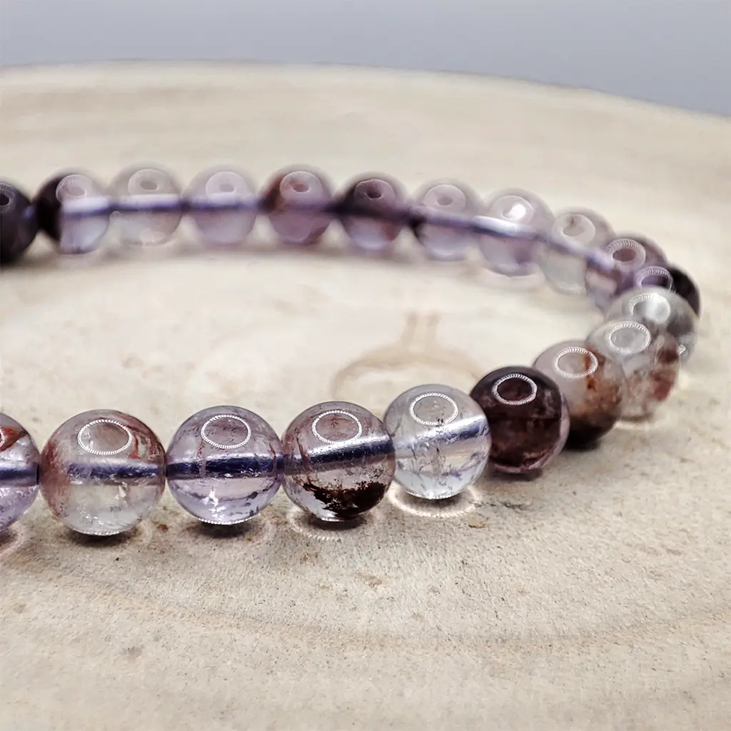 Pulsera de Super 7 de 6 mm con tonalidades violetas y transparentes.
