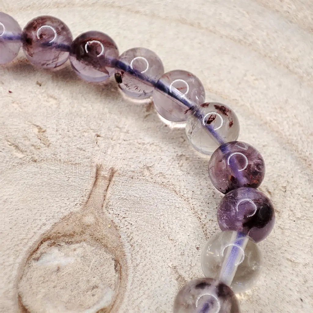 Pulsera de Super 7 de 6 mm con tonalidades violetas y transparentes.