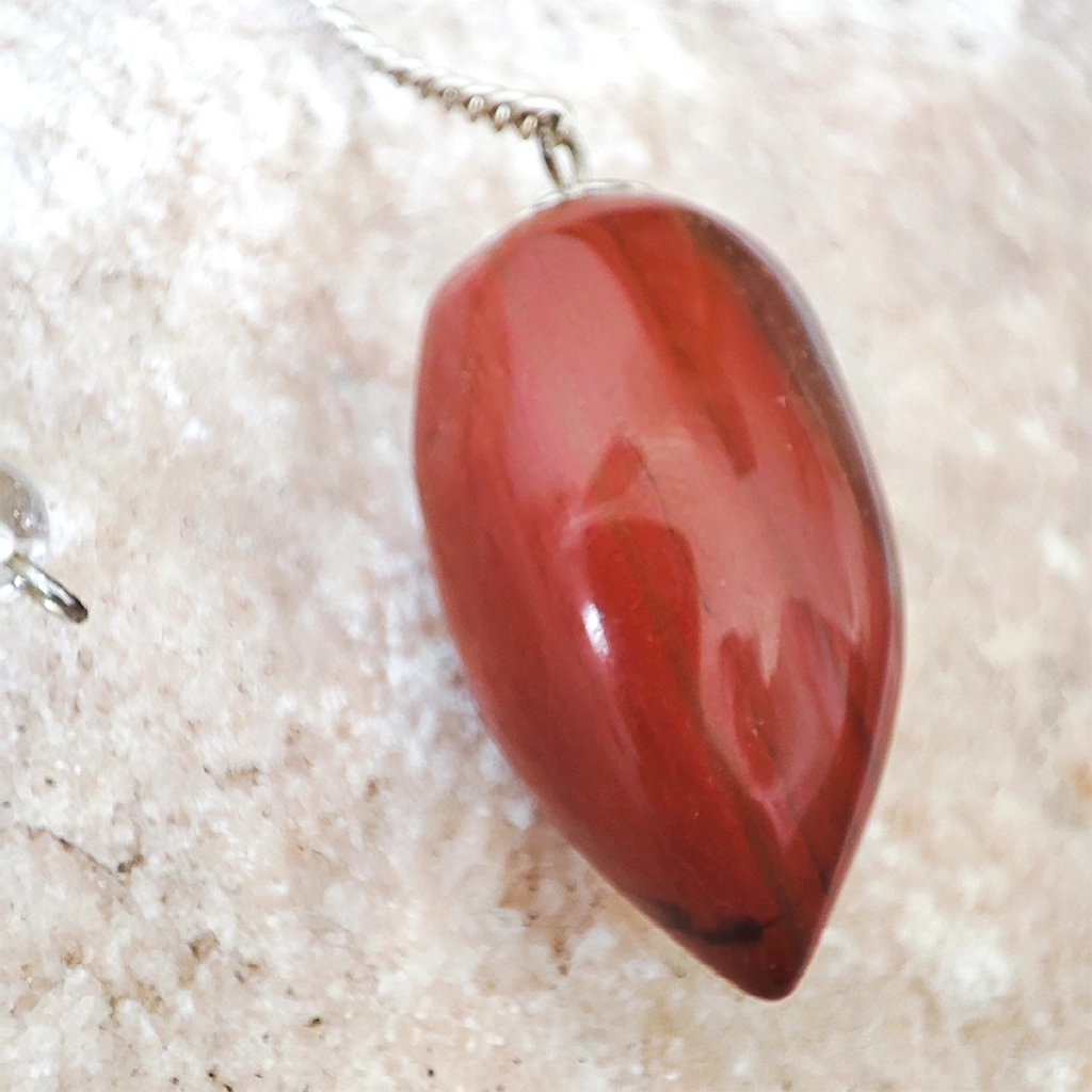 Péndulo Ovoide de Jaspe Rojo Péndulo ovoide de jaspe rojo con cadena plateada
