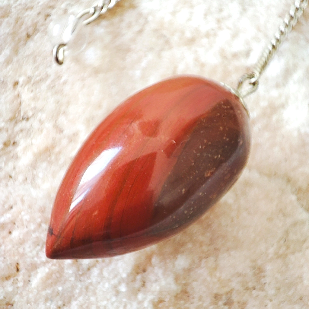 Péndulo Ovoide de Jaspe Rojo Péndulo ovoide de jaspe rojo con cadena plateada