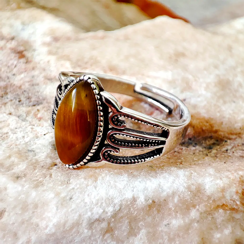 Anillo ajustable de metal plateado con piedra de ojo de tigre ovalada